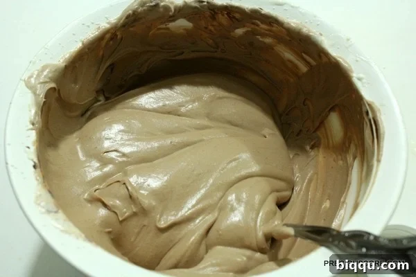 Gently folding chocolate spread into the cream mixture