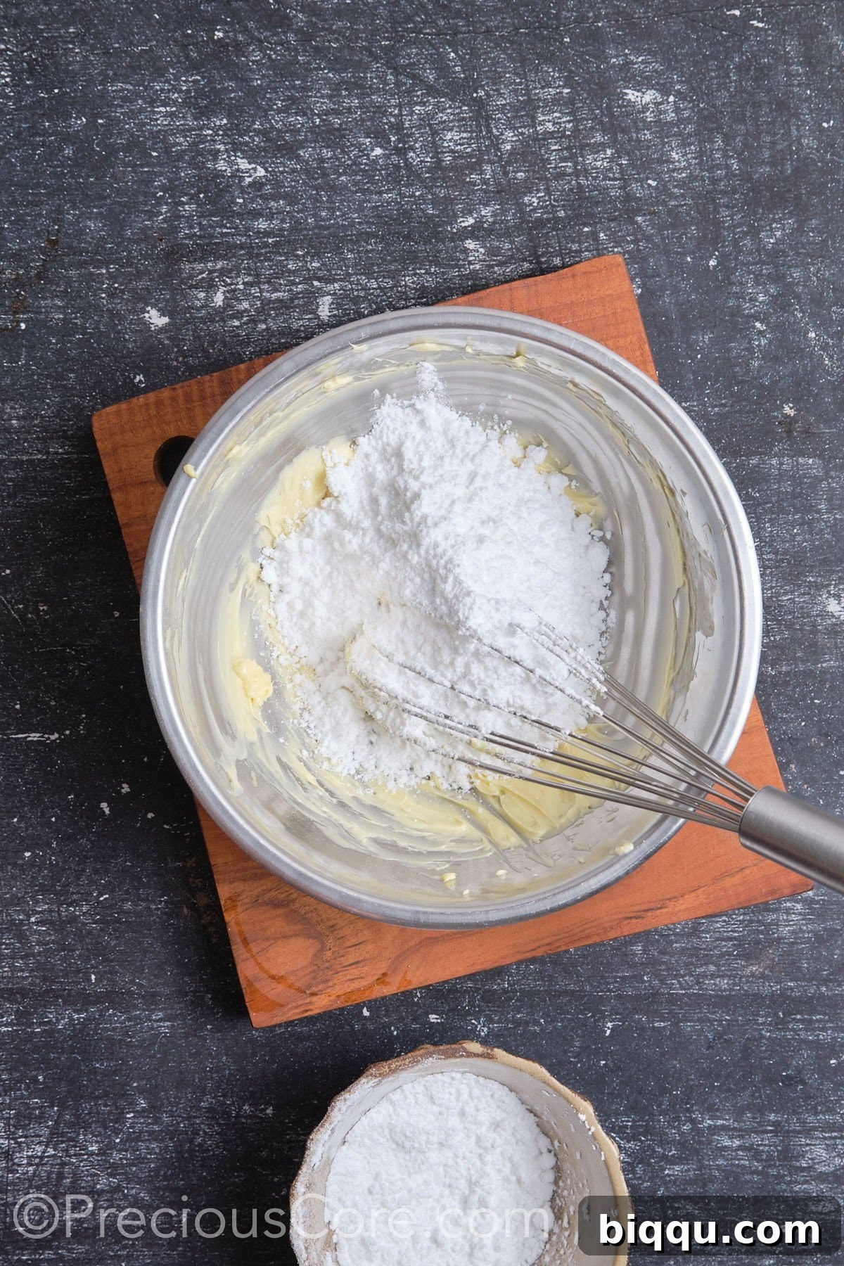 Butter and powdered sugar being whipped together for chocolate frosting.