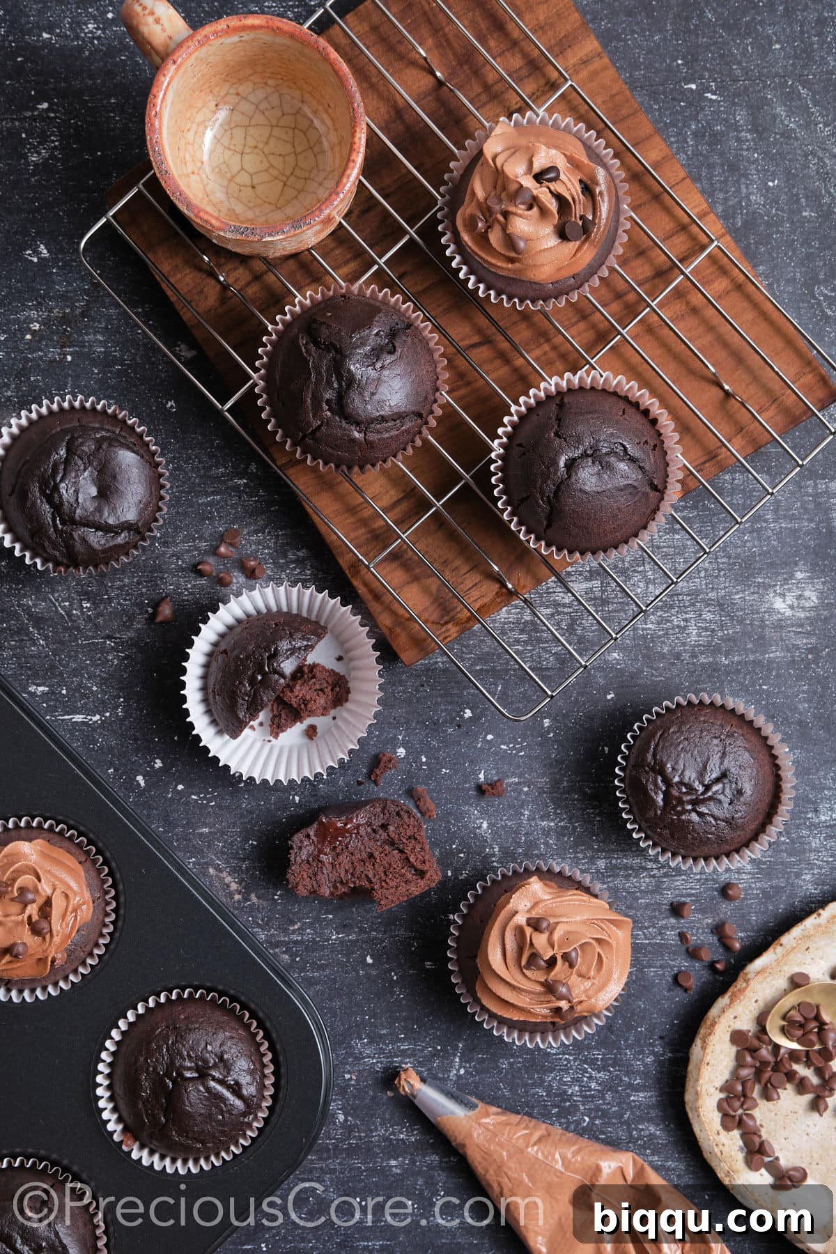 A hand frosting an easy moist chocolate cupcake with chocolate buttercream.