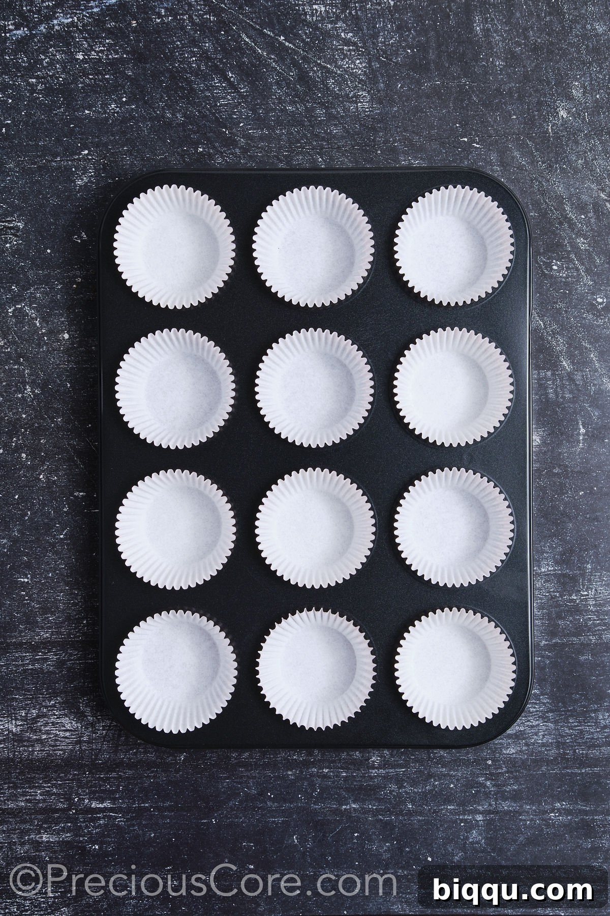 A muffin pan fully prepared with cupcake liners, awaiting the chocolate batter.