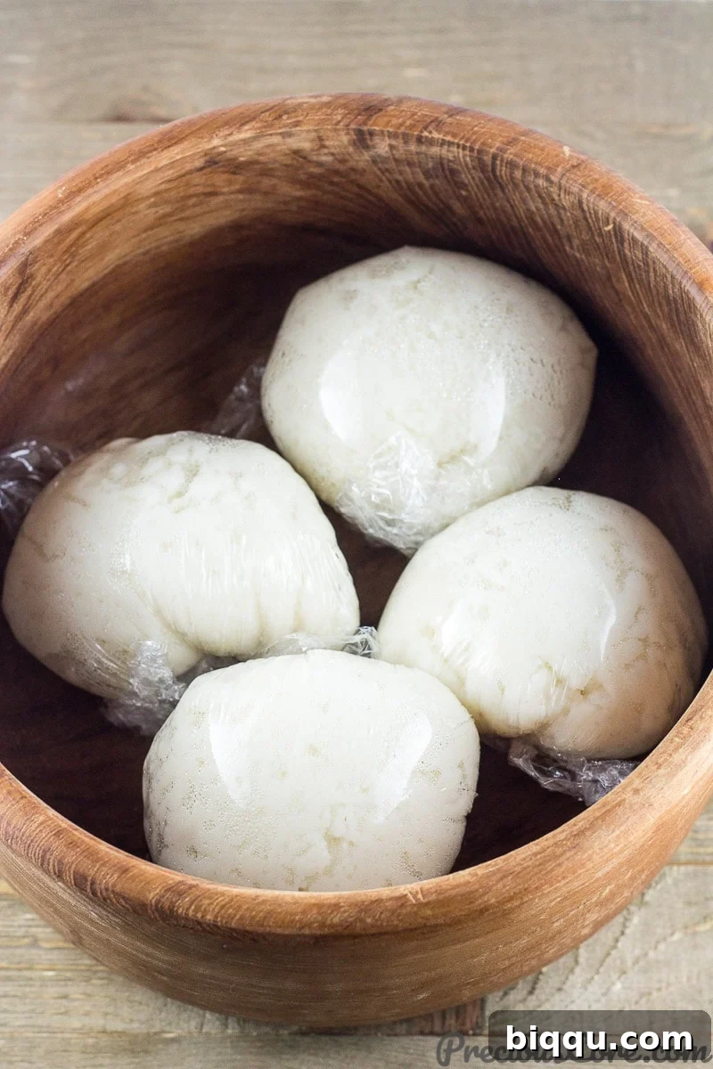 Wrapped corn fufu in a wooden bowl.