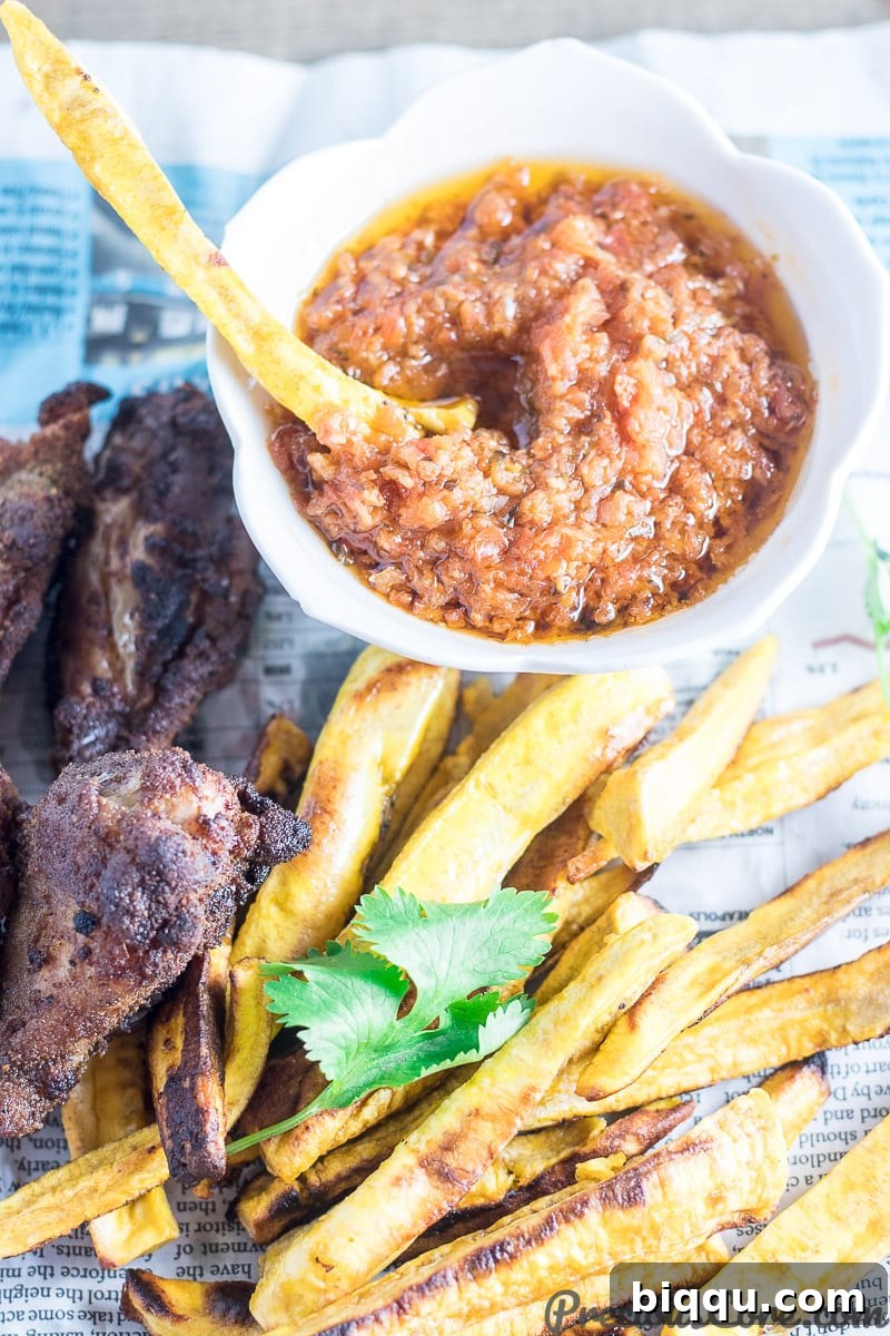 Baked plantain fries with various dipping sauces and crispy chicken wings, presented as a delicious spread for a meal.