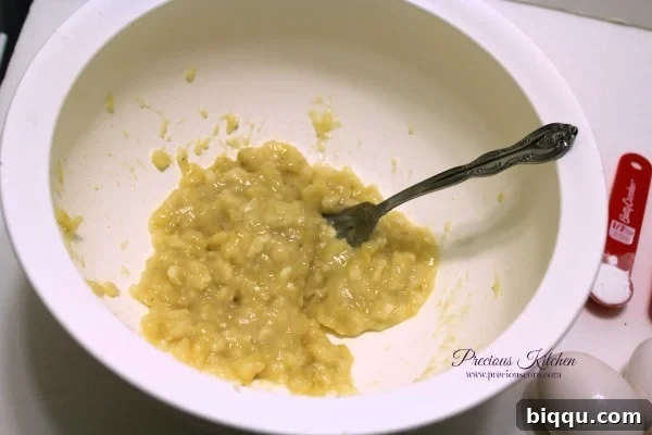 Mashing ripe bananas with a fork in a bowl