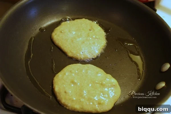 Scooping pancake batter onto a hot frying pan