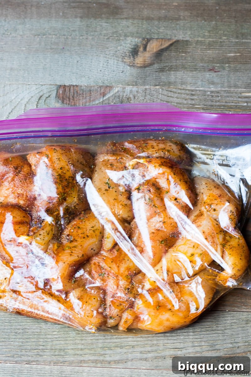 Chicken tenders marinating in a Ziploc bag with spices and olive oil