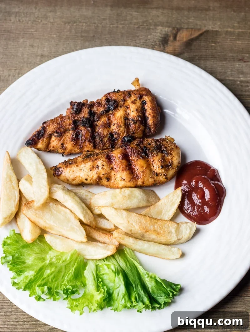 Grilled chicken tenders served hot with a side of crispy potato fries
