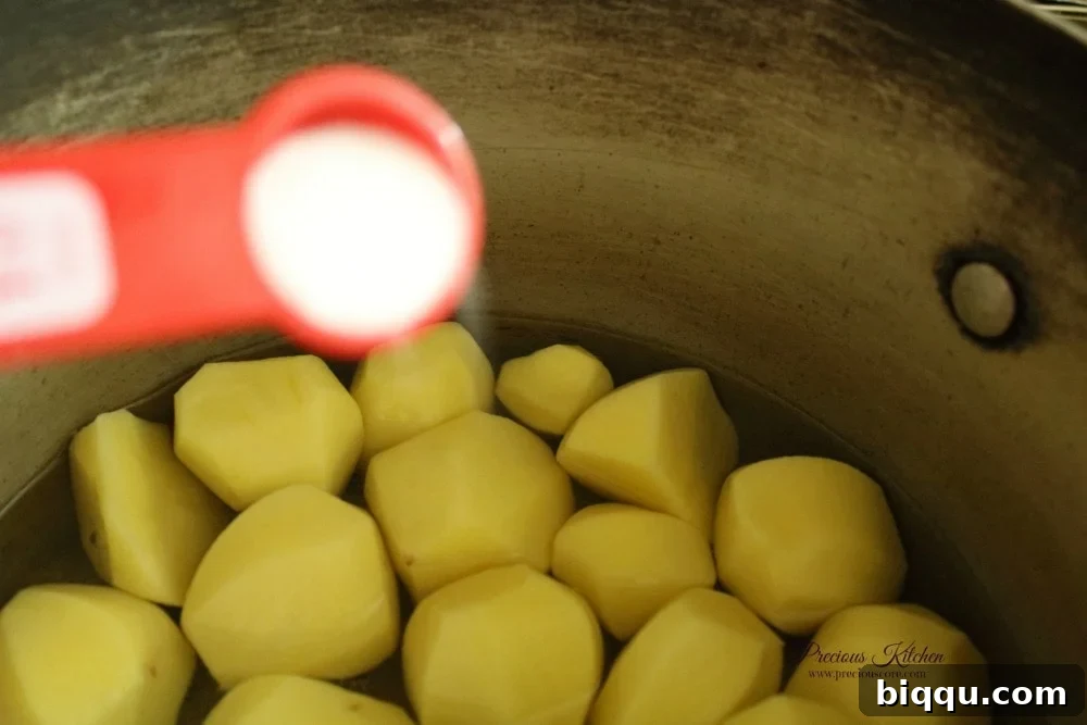 Peeled Irish potatoes boiling with salt for Pomme Pilées