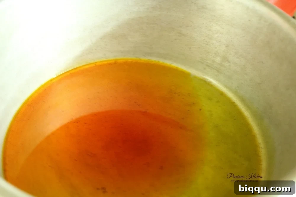 Palm oil heating in a pot, not bleached, for Cameroonian Mashed Potatoes and Beans