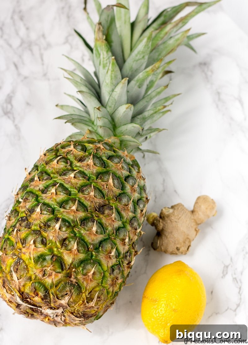 Tropical Ginger Kick 3 Fresh pineapple, ginger root, and a lemon on a wooden cutting board, ready for juicing to highlight health benefits.