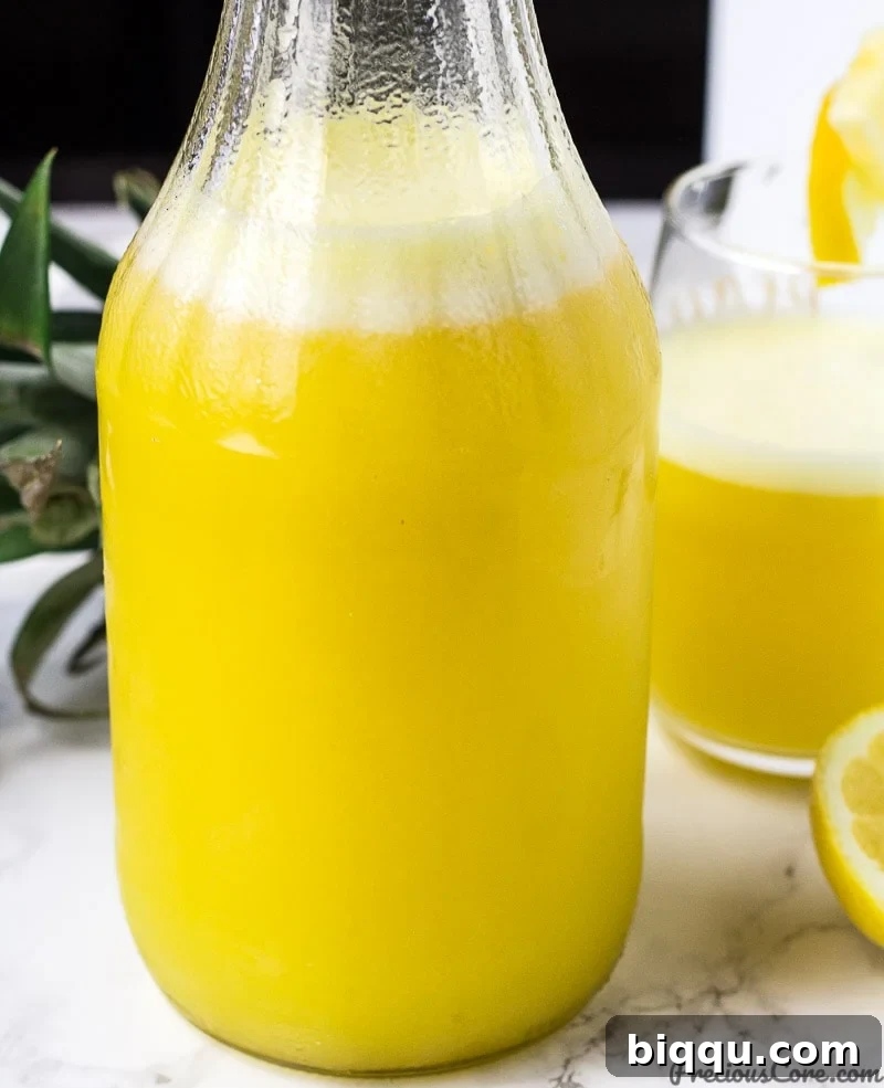 Tropical Ginger Kick 5 Homemade Pineapple Ginger Juice poured into a glass jar, ready to be served and enjoyed.
