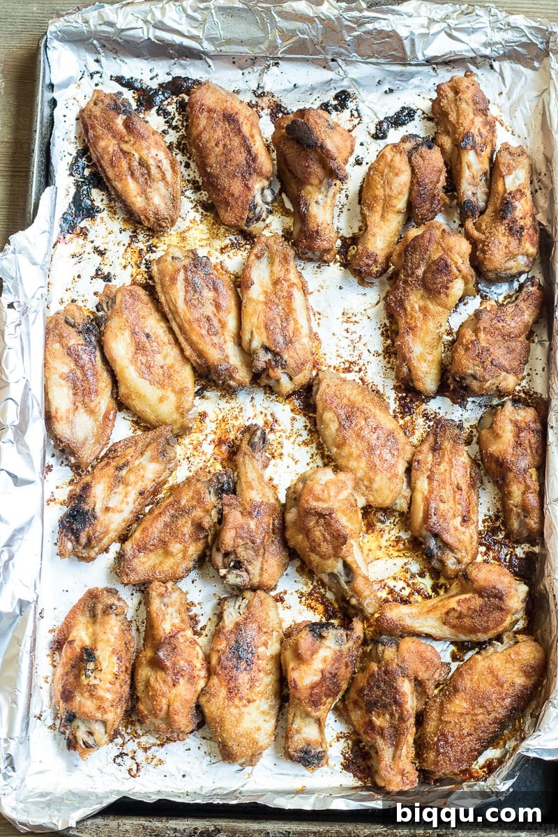 A tray of beautifully oven-grilled chicken wings, golden-brown and perfectly crispy, just pulled from the oven.