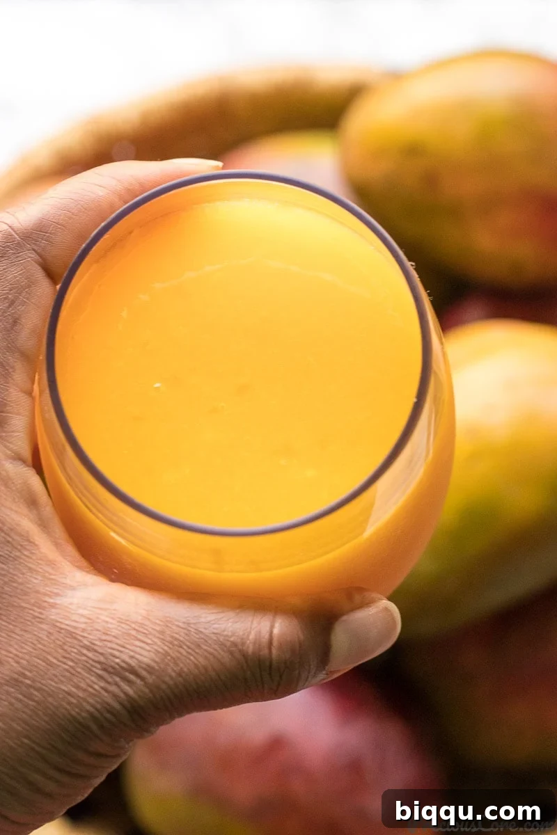 A cup of homemade mango juice served over ice