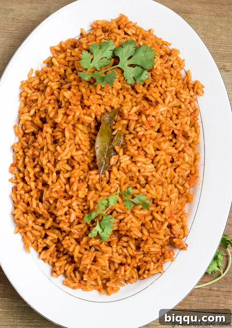 Authentic Nigerian Jollof Rice with chicken, garnished with fresh vegetables