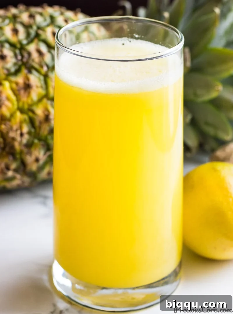Pineapple Ginger Juice - A refreshing glass of golden pineapple ginger juice, garnished with a slice of pineapple and a sprig of mint, ready to invigorate and boost immunity.