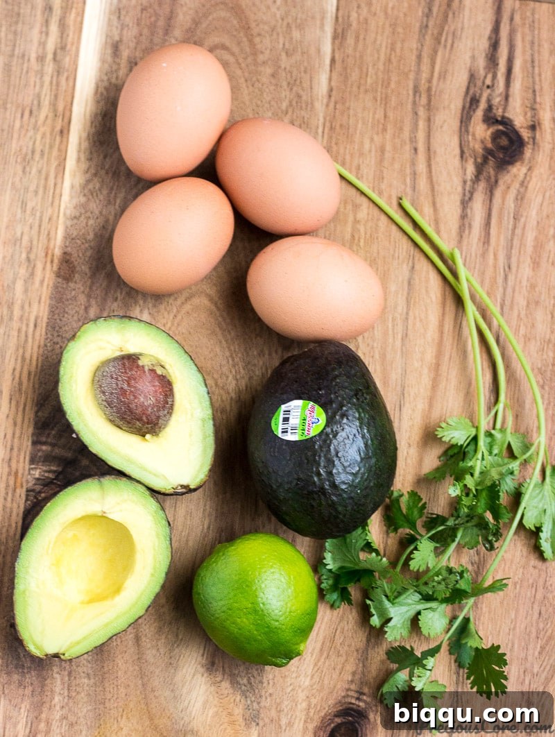 Fresh ingredients for a healthy avocado egg salad, including ripe avocados, hard-boiled eggs, and lime.