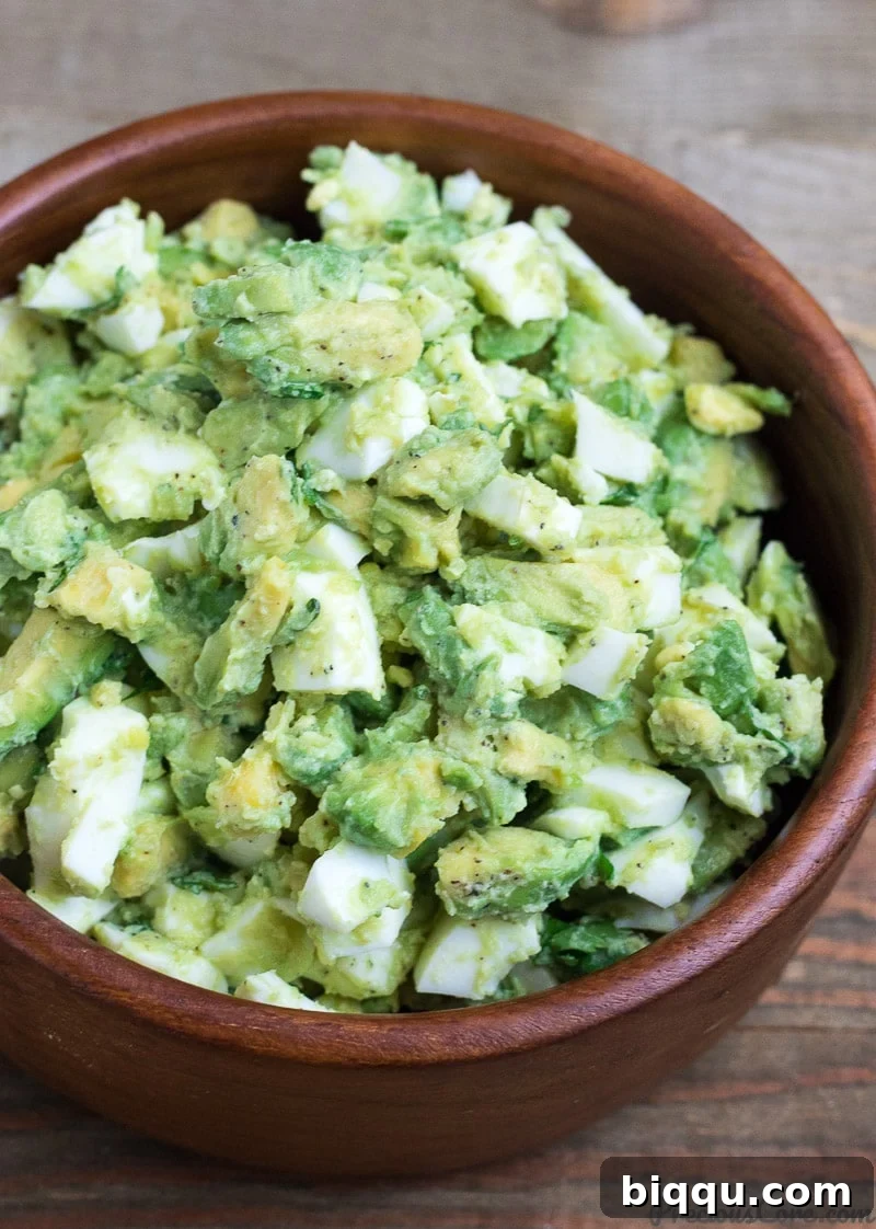 Step-by-step preparation of avocado egg salad, showing chopped ingredients being mixed in a bowl.