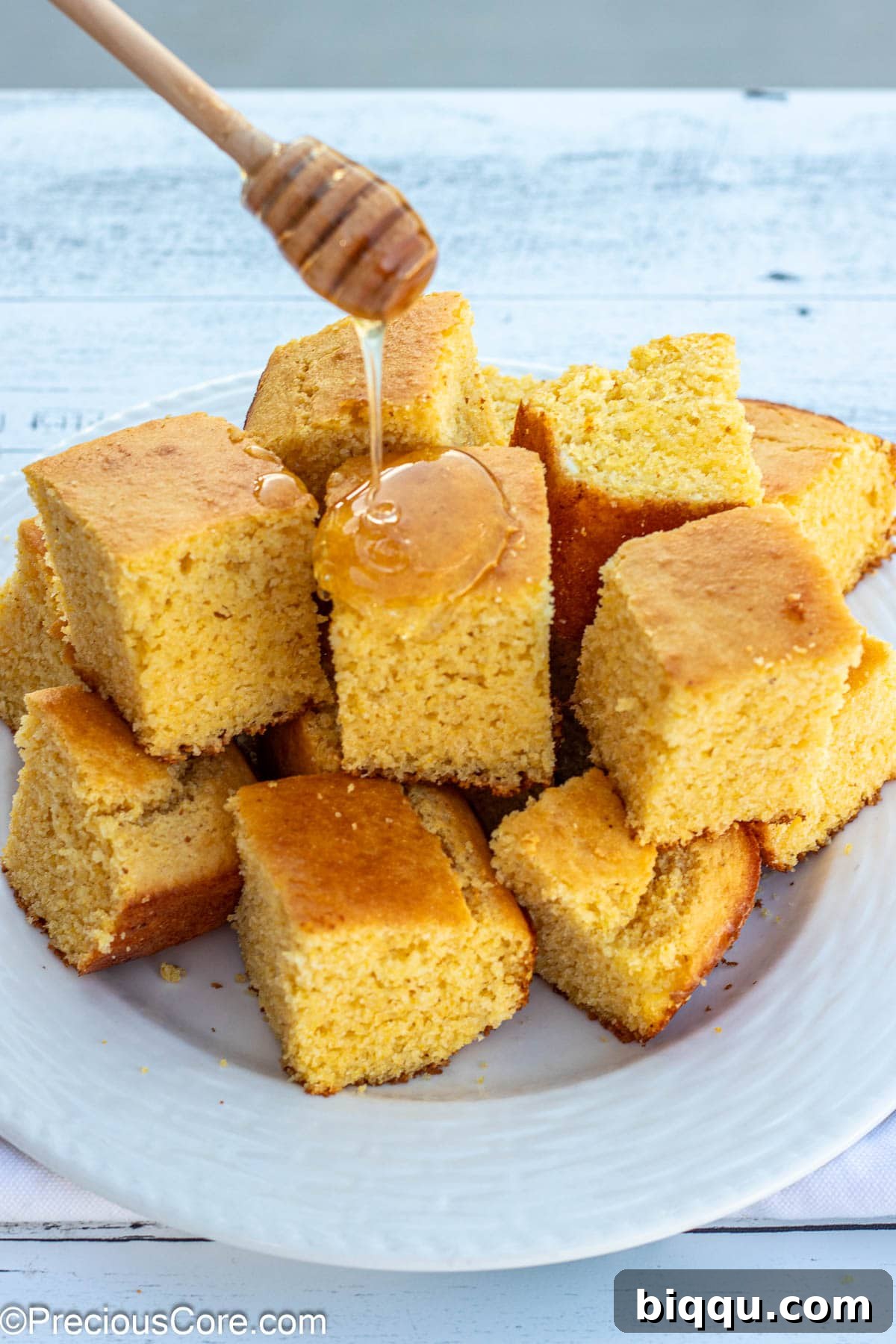 Fluffy Cornbread Without Buttermilk 4 Honey wand drizzling honey on cornbread.