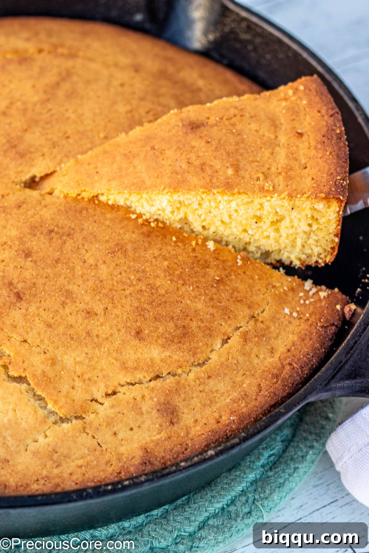 Fluffy Cornbread Without Buttermilk 10 Slice of cornbread being lifted from a cast iron skillet.