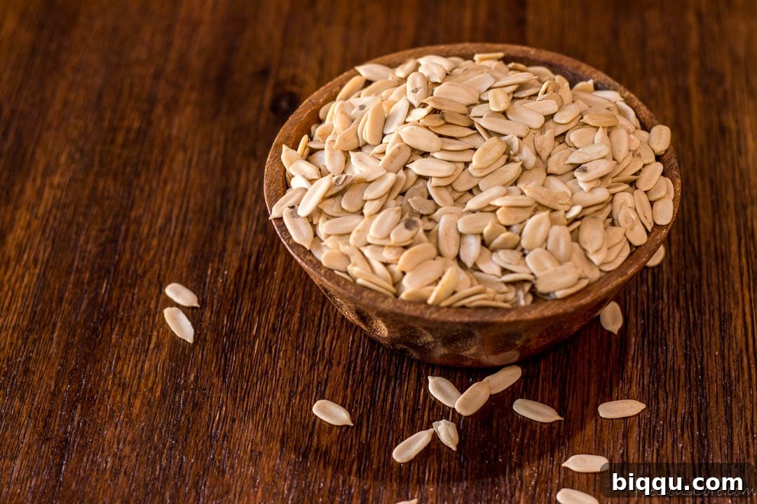 Egusi seeds in a wooden brown bowl, showcasing their distinct white appearance.