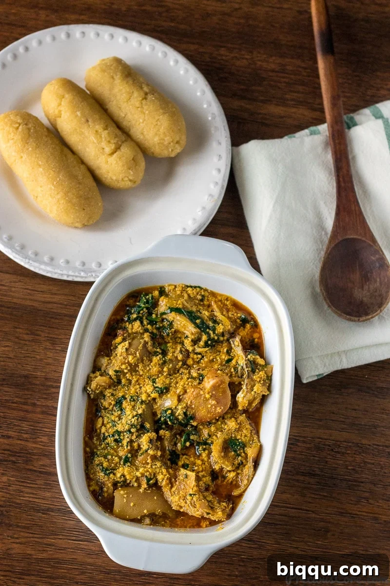 Melon seed Soup served with Garri (Eba) in a white bowl, ready to be eaten.