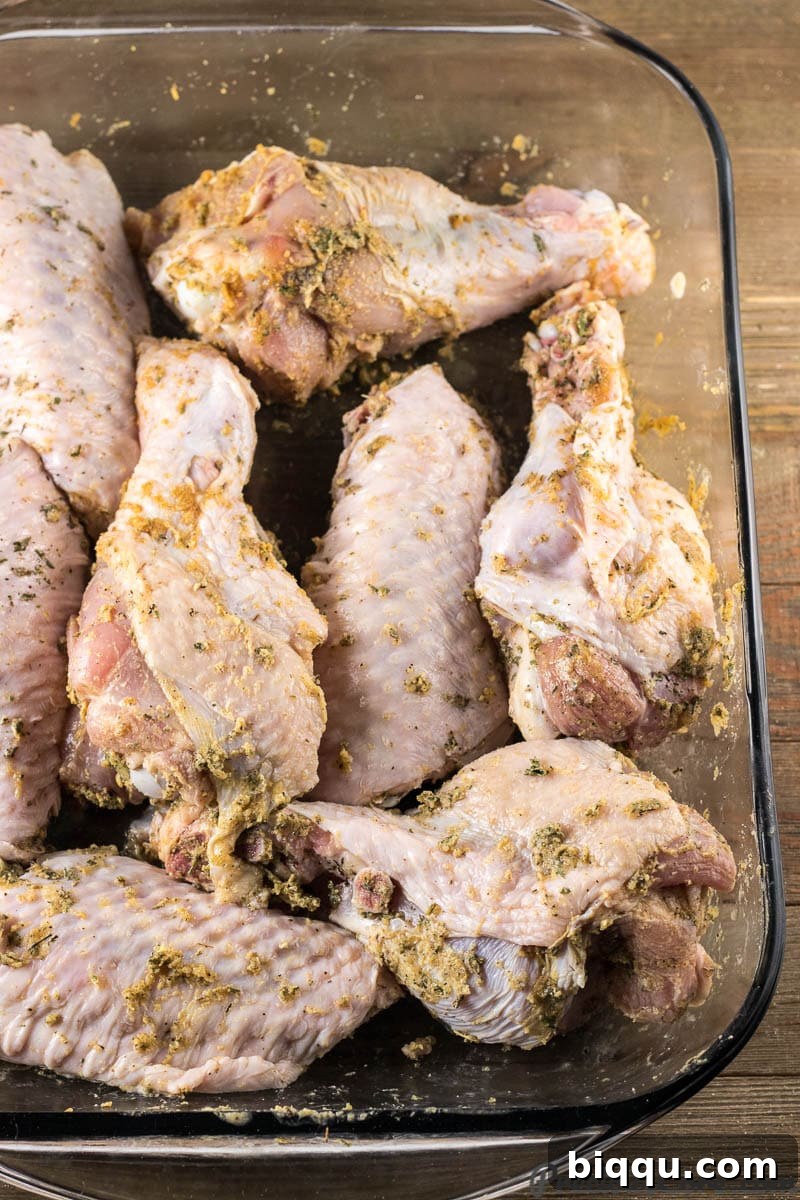 Raw turkey wings perfectly seasoned and arranged in a baking dish, ready for the oven.