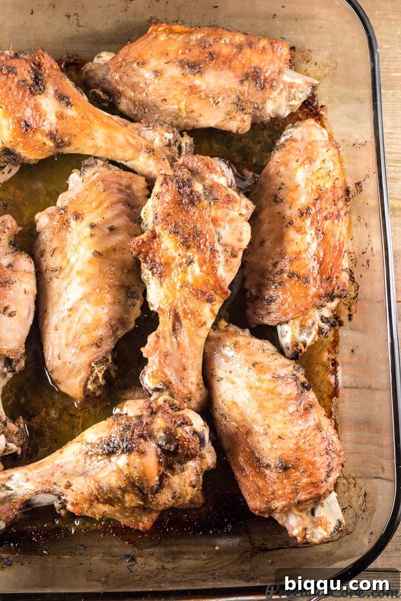 Crispy, golden-brown baked turkey wings sizzling in a baking dish straight from the oven.