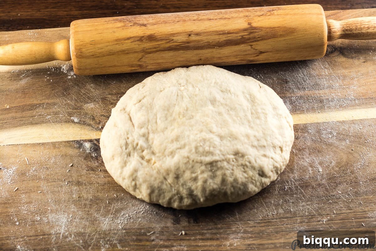 Mandazi East African Doughnuts 7 Hands kneading a smooth and elastic Mandazi dough on a floured surface.