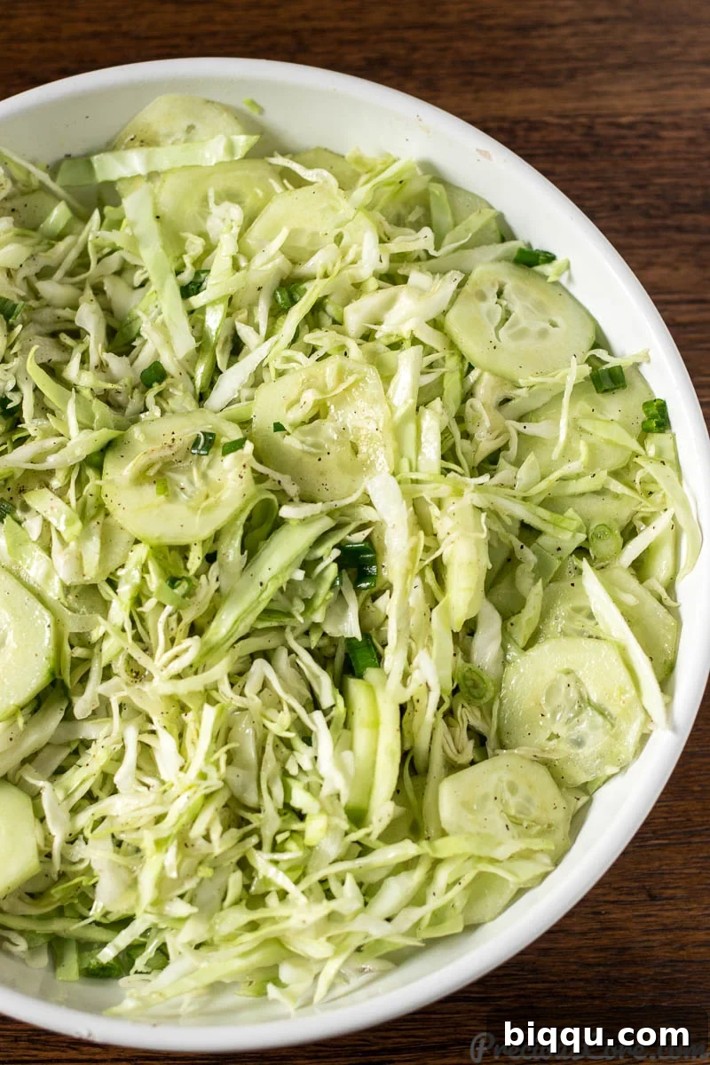 Zesty Cabbage Delight 7 Easy cabbage salad, showing the dressing being drizzled over the vegetables.