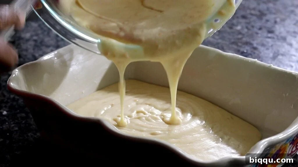 pouring batter into baking dish for South African Malva Pudding Recipe