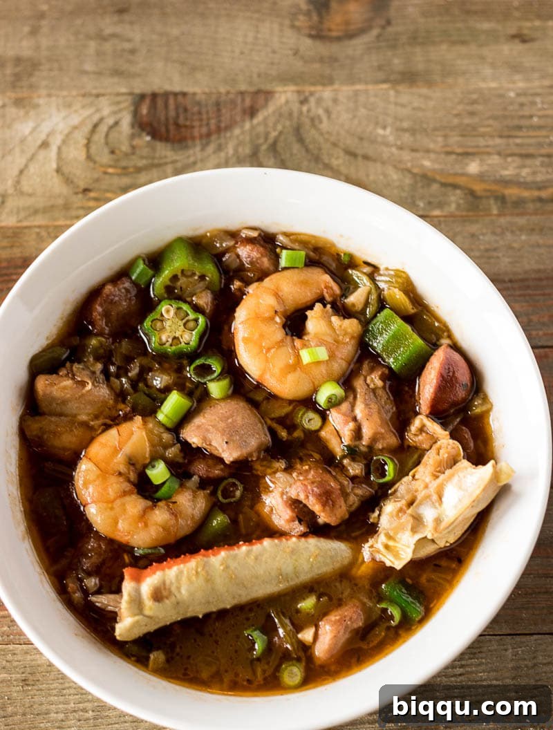 A large bowl of authentic Seafood Gumbo, showcasing its rich, dark color and generous portions of seafood and meat.