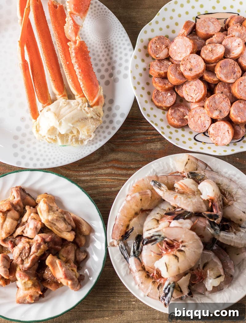 Assortment of main protein ingredients for gumbo: crab legs, sliced andouille sausage, baked boneless skinless chicken thighs, and large raw shrimp.