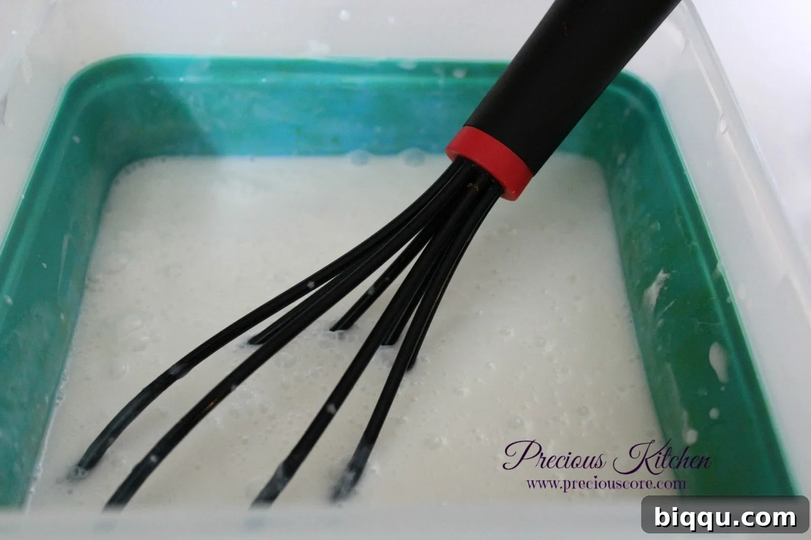 All the liquid ingredients for coconut ice cream mixed together in a large plastic bowl, ready for freezing.