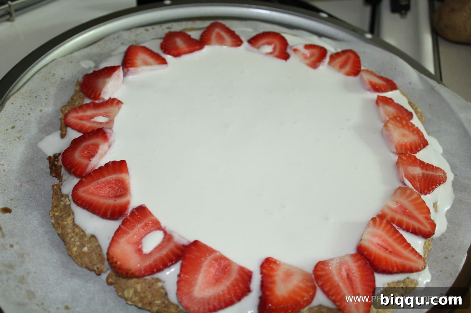Healthy fruit pizza topped with a variety of colorful sliced fruits.