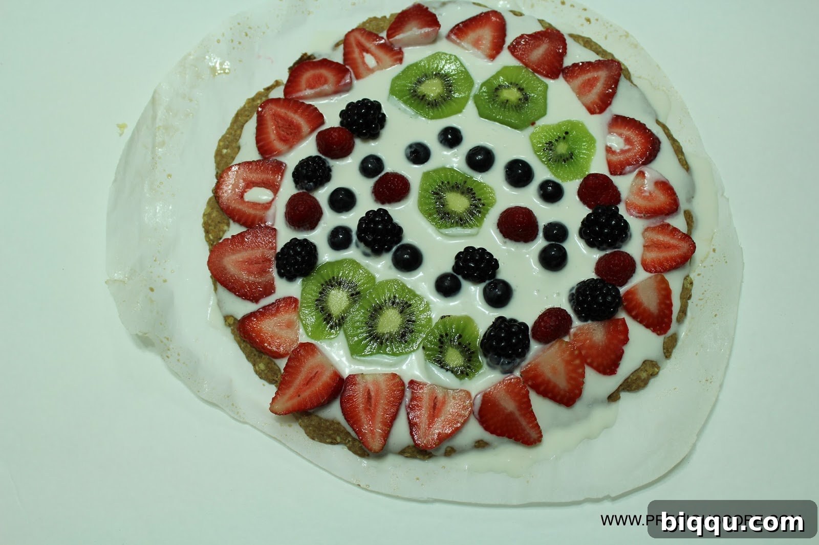 Close-up of a slice of healthy fruit pizza, ready to be enjoyed.