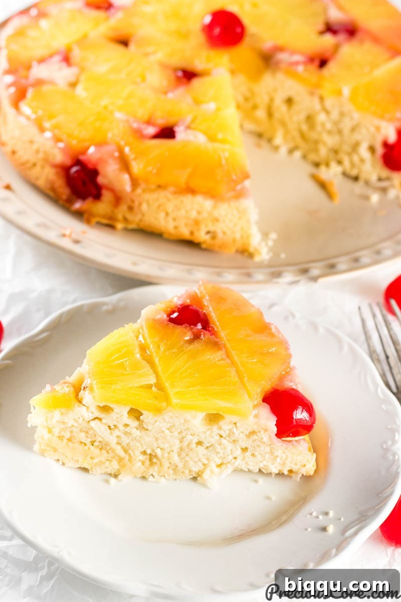 A whole, stunning Pineapple Upside Down Cake, perfectly baked with vibrant pineapple slices and cherries on top, ready to be served.