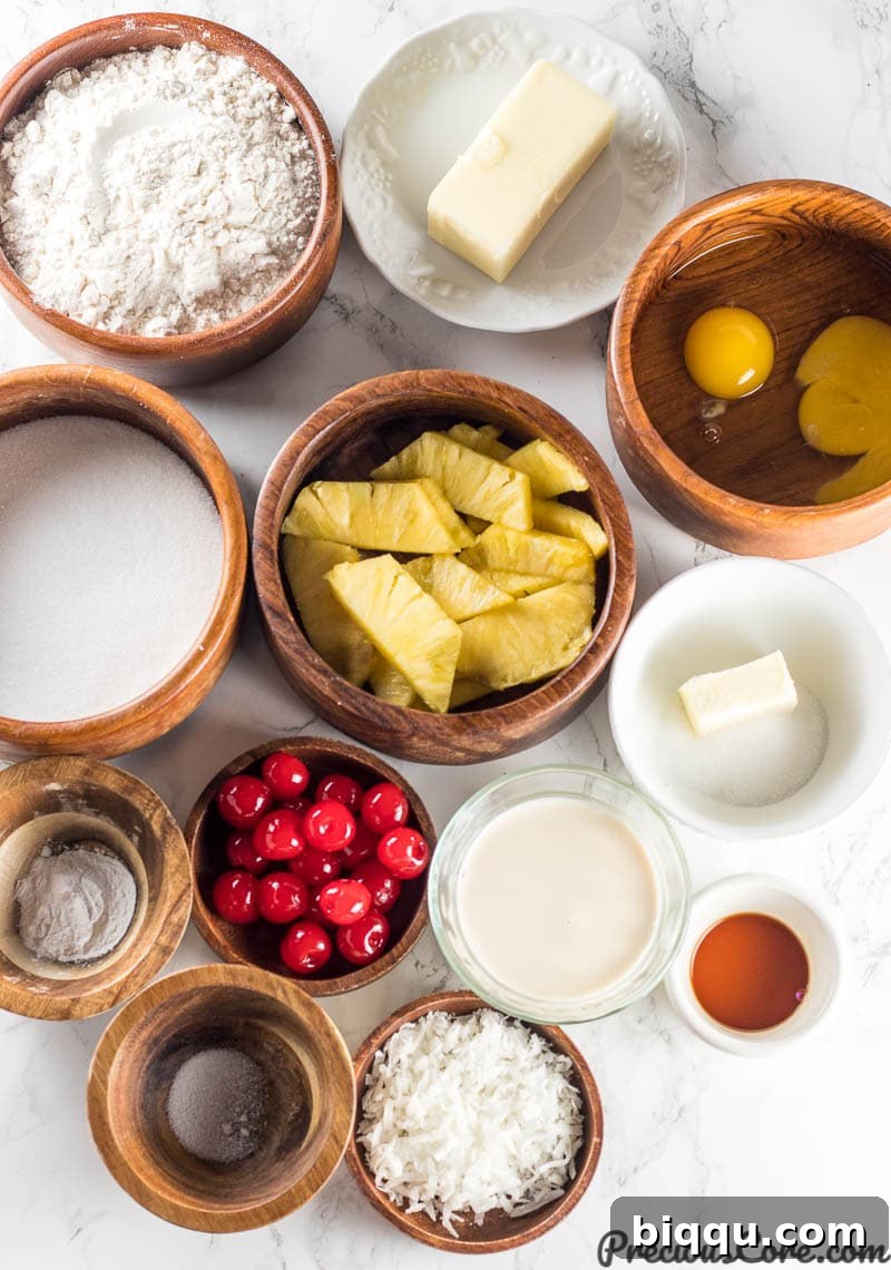 All the essential ingredients for making Pineapple Upside Down Cake laid out neatly on a kitchen counter, including fresh pineapple, butter, sugar, flour, eggs, milk, vanilla, and cherries.