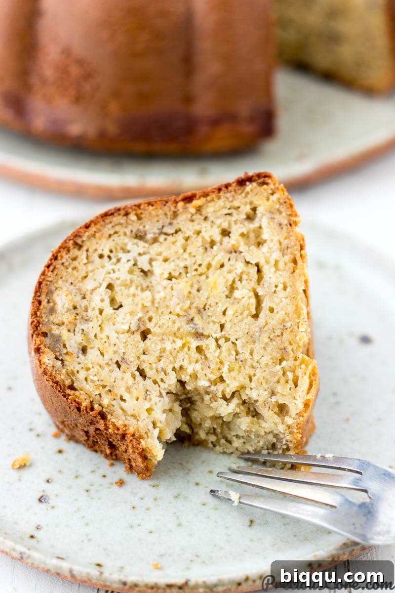 A perfectly portioned slice of plantain cake on a plate with a fork, emphasizing its delightful texture.