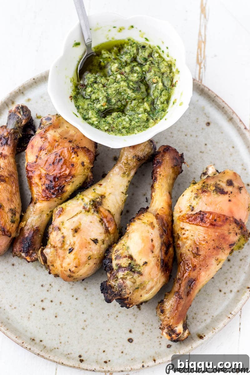 Grilled chicken thighs served on a plate with a side of green sauce, highlighting the seasoning's use.