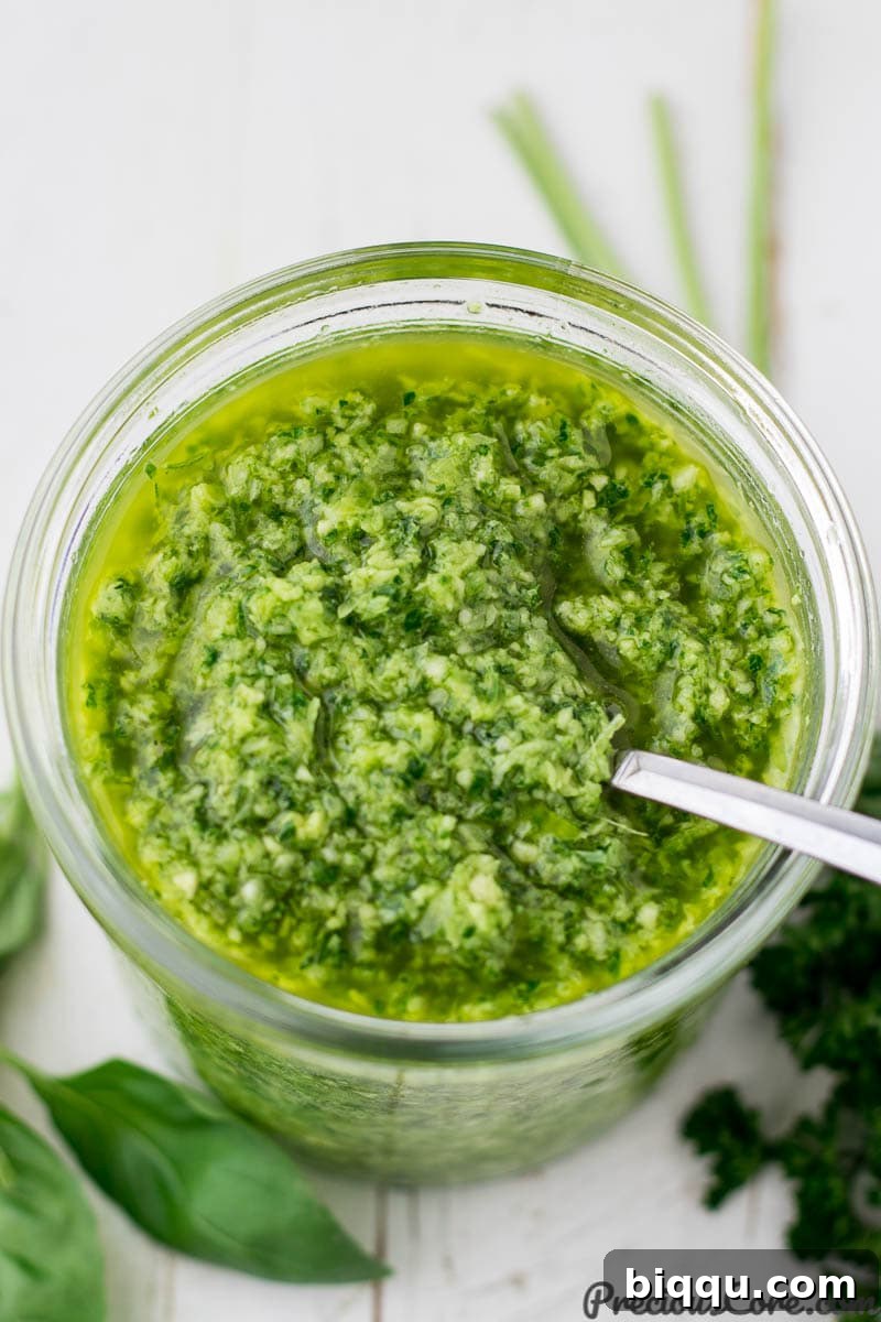 A large jar filled with the vibrant green seasoning, showcasing its fresh and potent appearance.