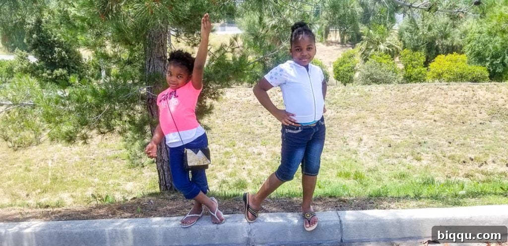 Two stylish girls posing playfully on a curb, showcasing their wonderful photography poses.