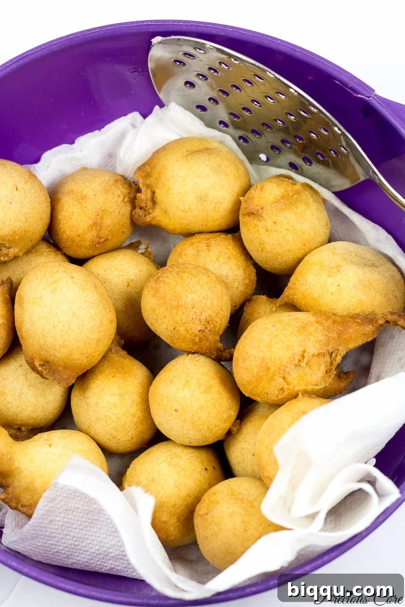 Cameroonian doughnuts freshly drained on paper towels in a bowl.