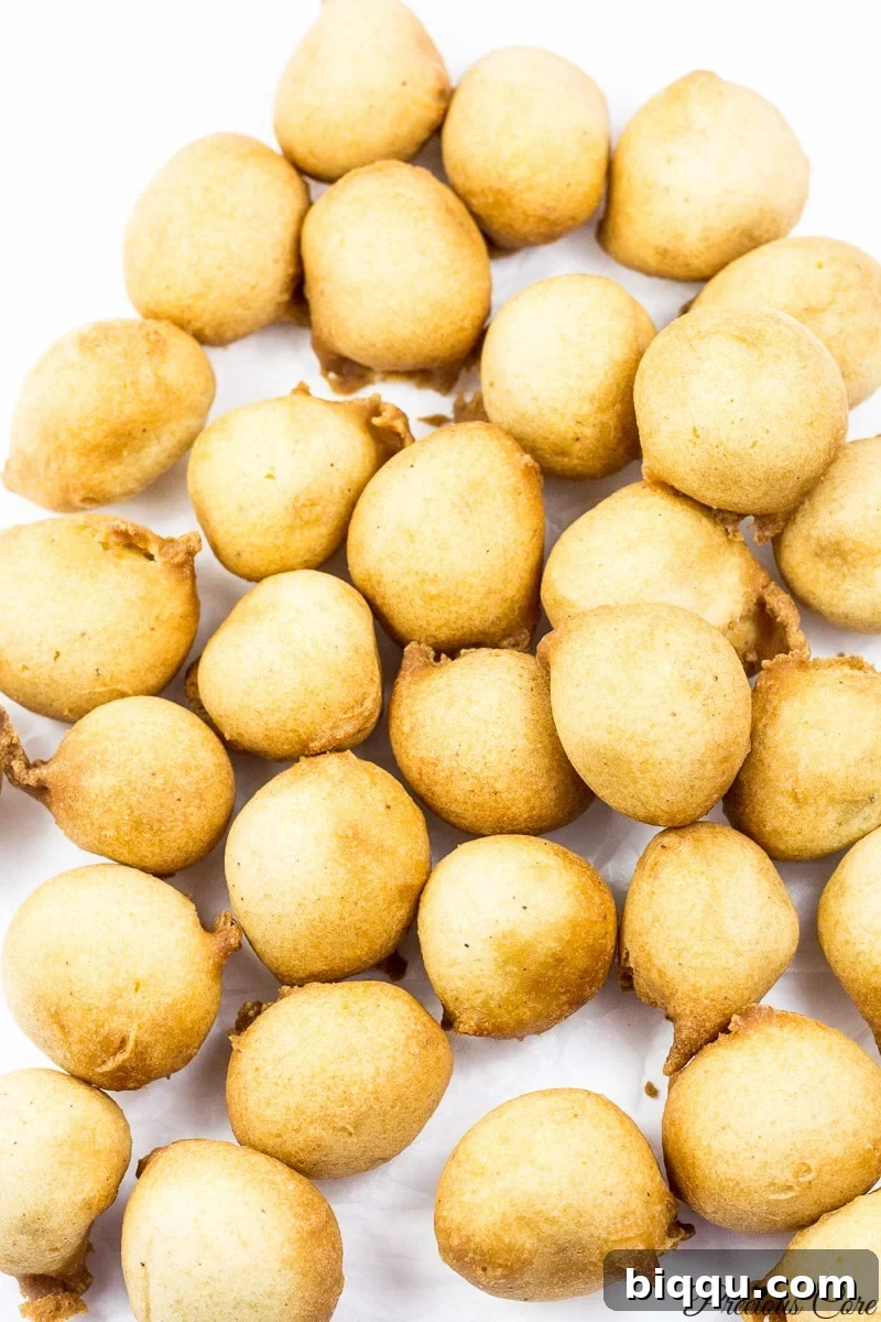 Several golden-brown Cameroon doughnuts piled high, ready to be enjoyed.