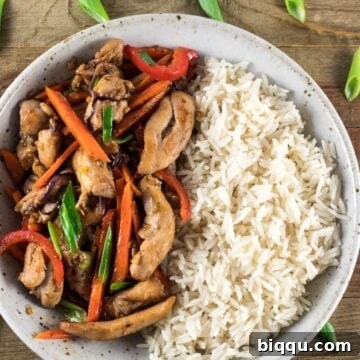 Quick & Flavorful Chicken Stir-Fry 2 A colorful bowl of easy chicken stir fry with jasmine rice, garnished with green onions.