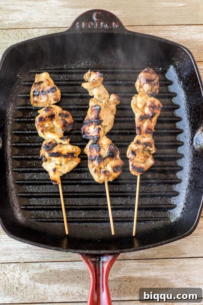 Succulent chicken skewers sizzling on a hot grill pan, forming beautiful char marks