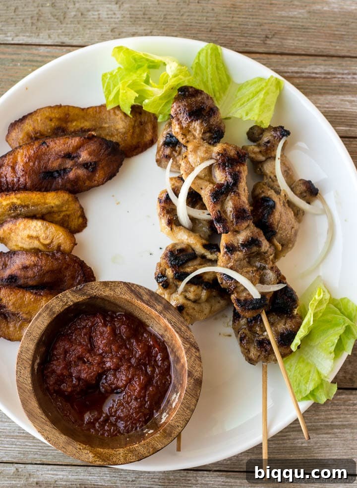 Plated chicken skewers alongside golden fried plantains, a perfect pairing
