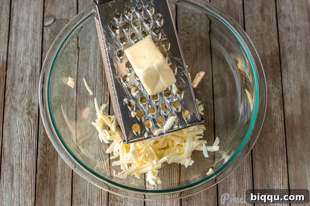 Grated cold butter in a large mixing bowl, ready for dry ingredients.