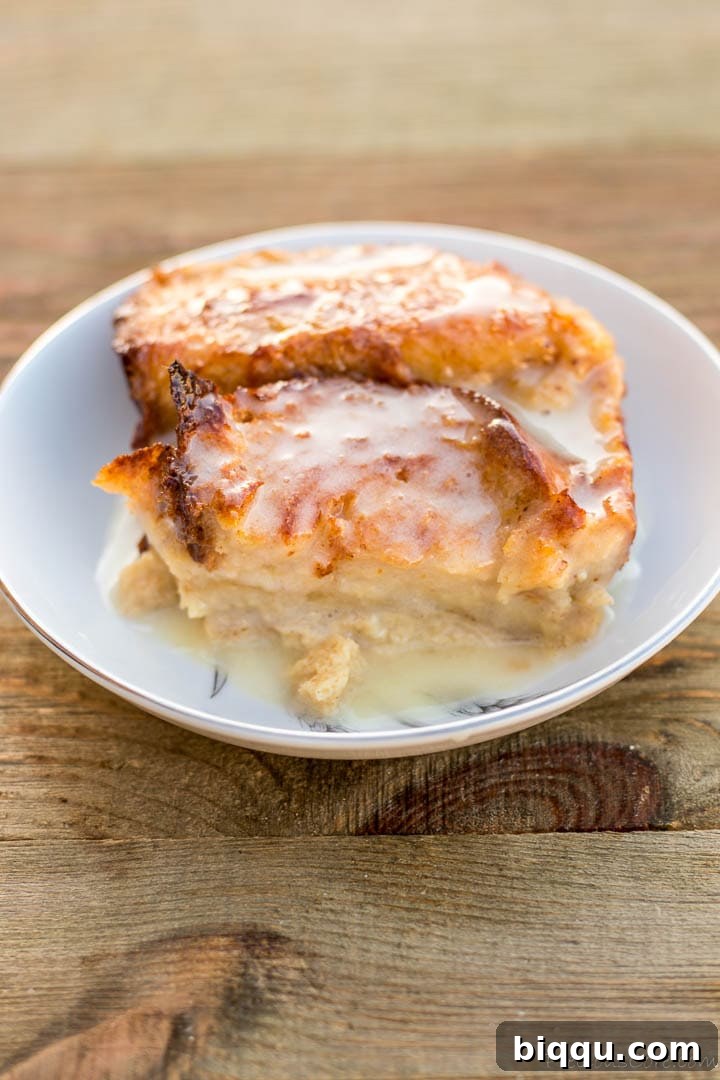 A close-up of warm bread pudding, generously soaked in a rich and creamy bread pudding sauce, with a hint of cinnamon, ready to be savored.