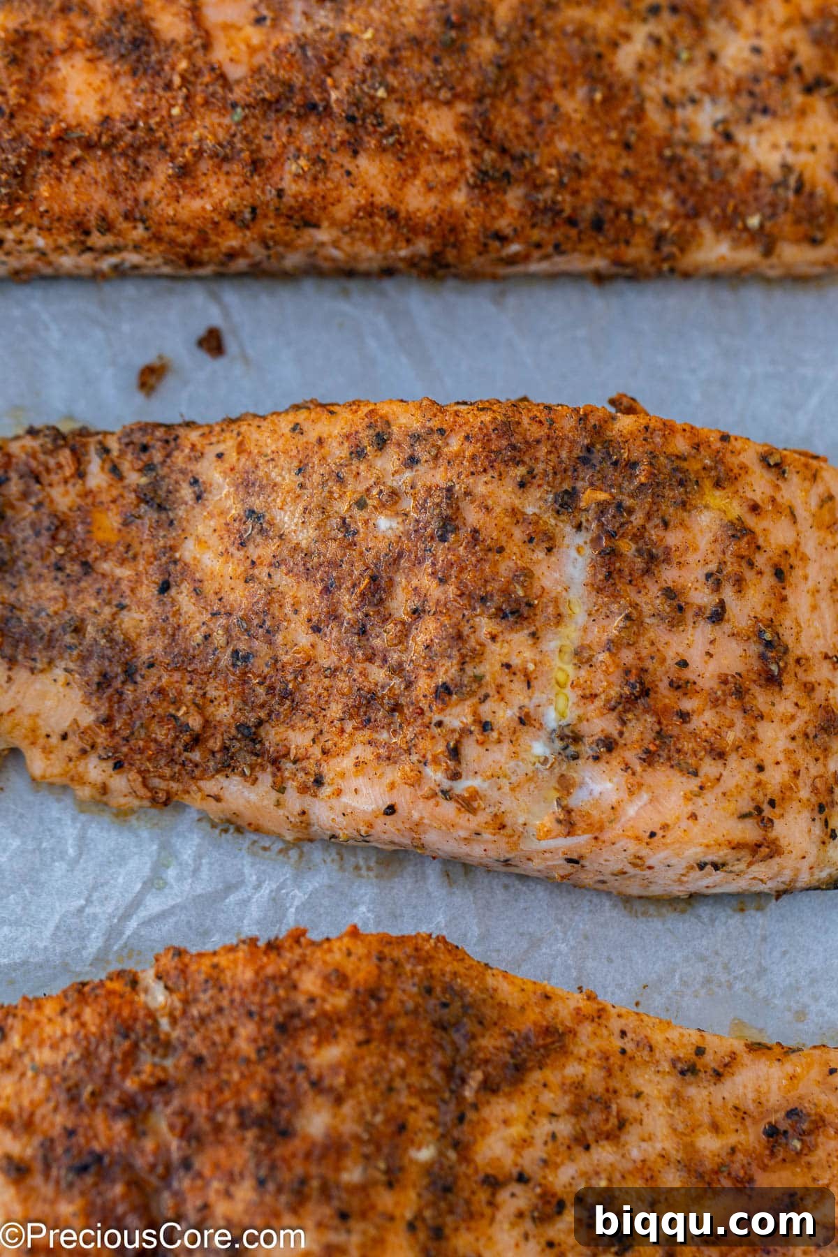 Baked Cajun salmon on parchment paper, fresh out of the oven.