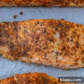 Baked Cajun salmon on parchment paper.