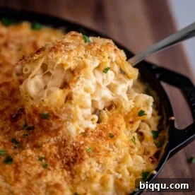 Spoon lifting up creamy mac and cheese from a bowl